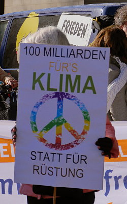 Demoschild: '100 MILLIARDEN FÜR'S KLIMA STATT FÜR RÜSTUNG'